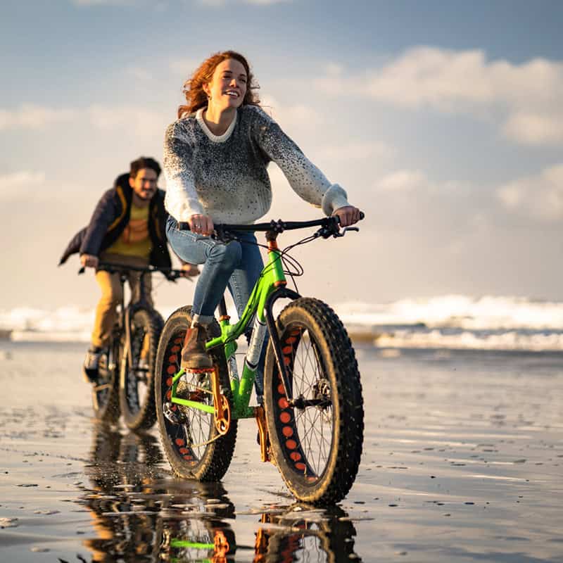 People riding bikes on the beach
